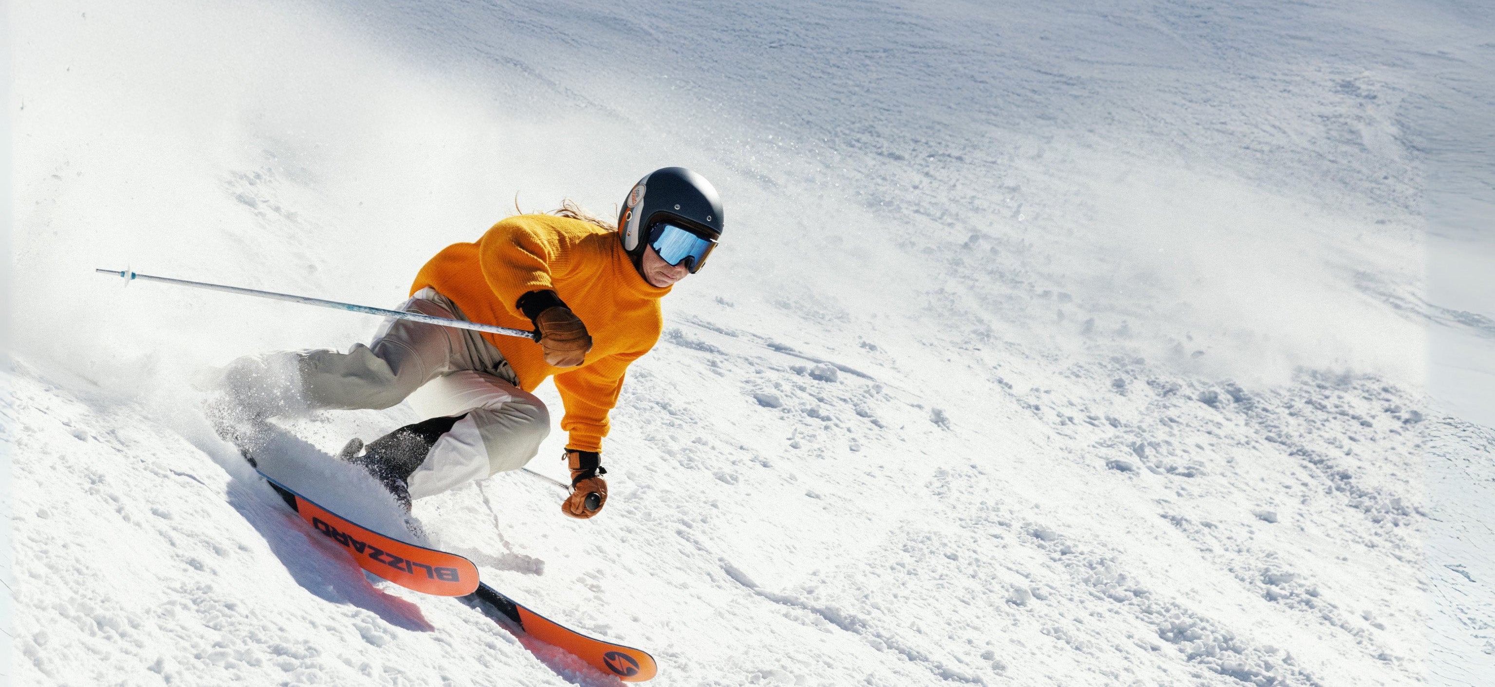 Person skiing down a snowy slope with a bright yellow jacket